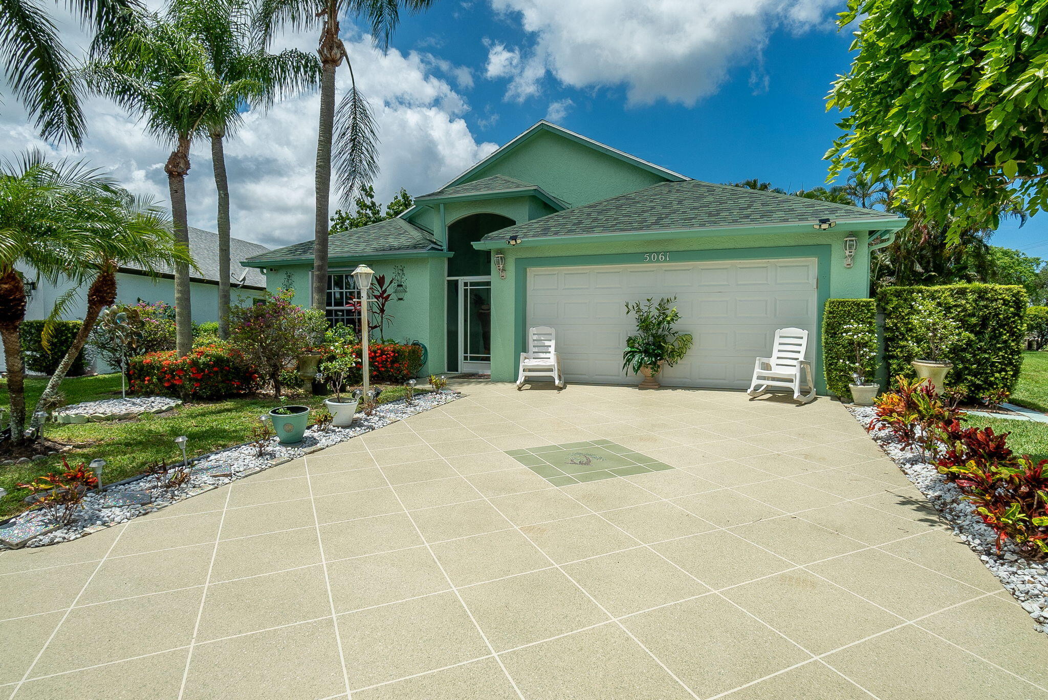 a view of a house with a yard and potted plants