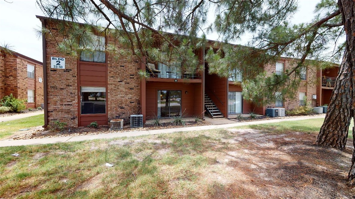 a view of a house with a yard and tree