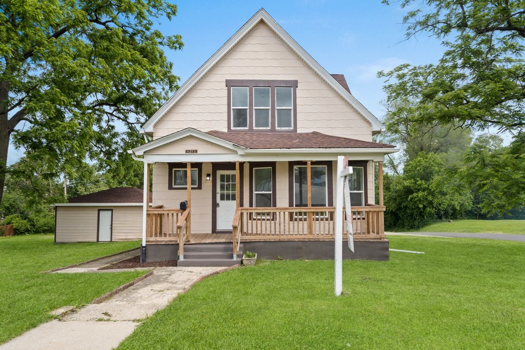 a front view of a house with a yard and trees