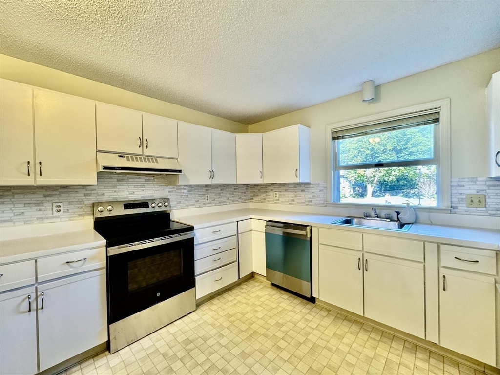 a kitchen with granite countertop white cabinets and white appliances