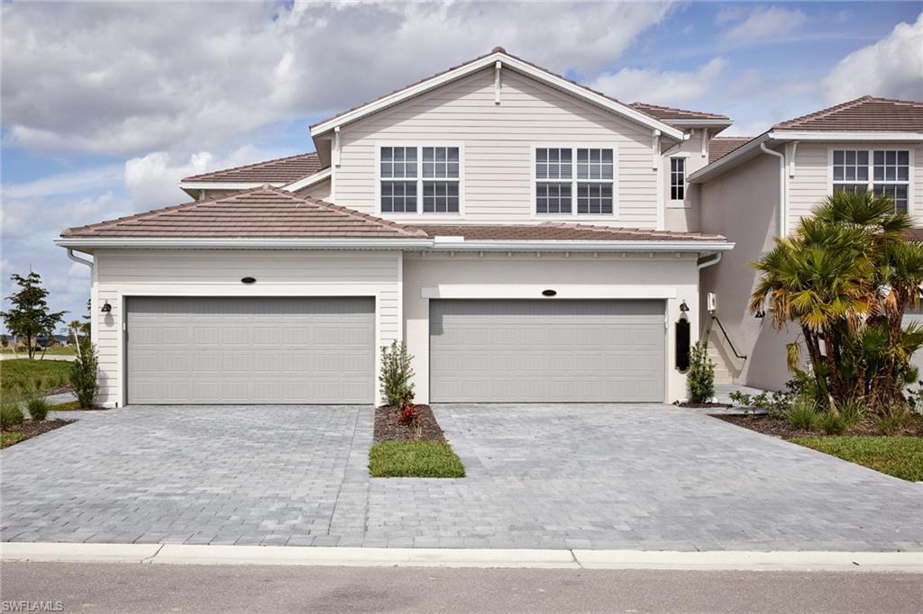 a front view of a house with yard and garage