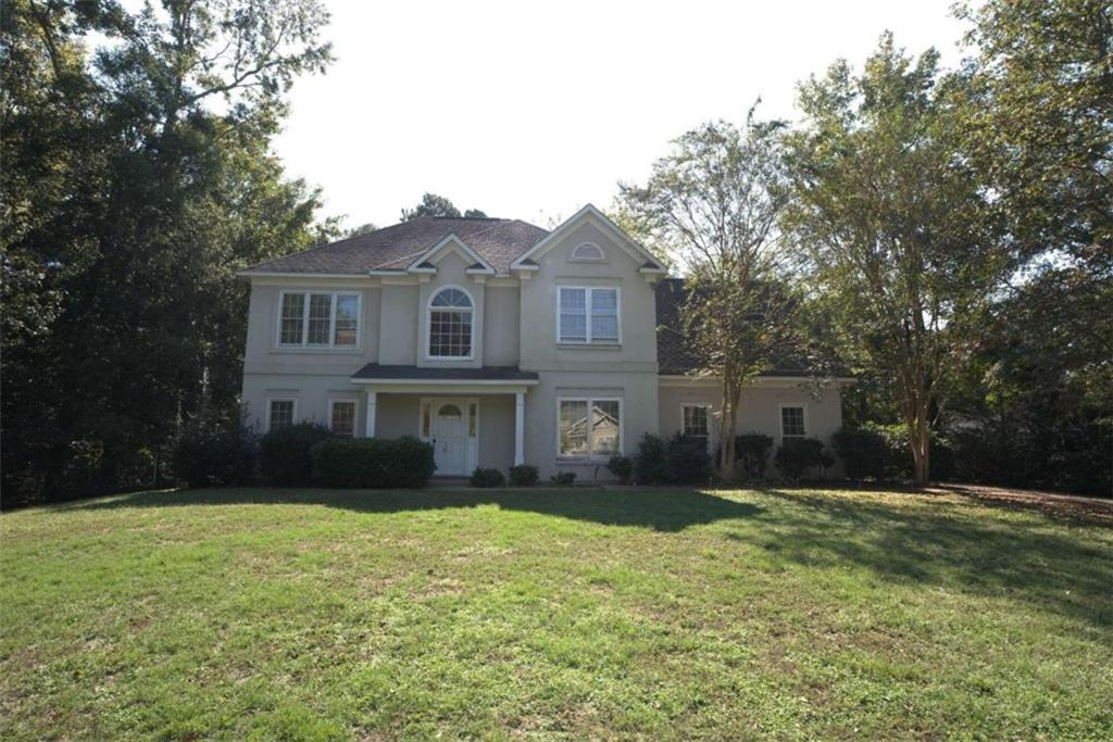 a front view of house with yard and trees