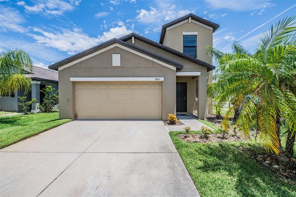 a front view of a house with a yard and garage