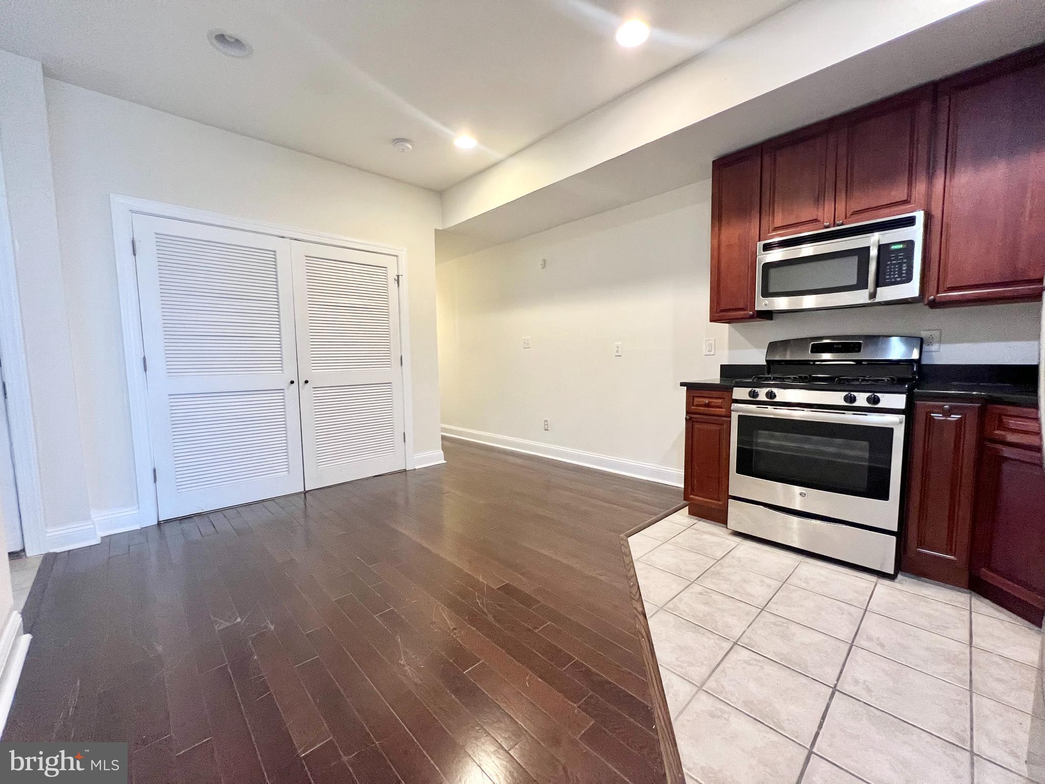 a kitchen with granite countertop wooden floors and stainless steel appliances