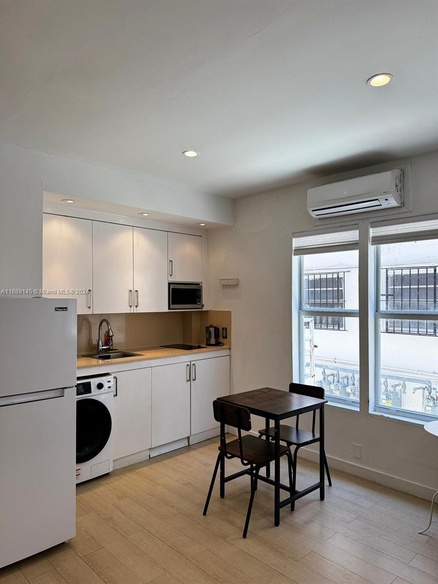 a kitchen with kitchen island a dining table chairs and a refrigerator