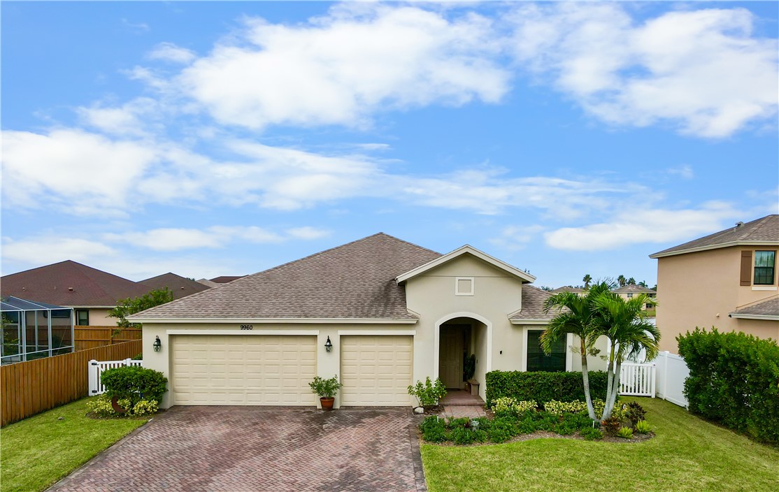 a front view of a house with a garden and plants