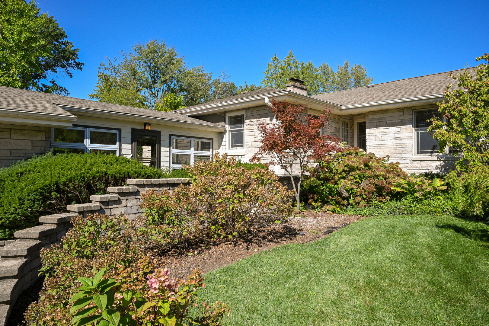 a front view of house with yard and trees around