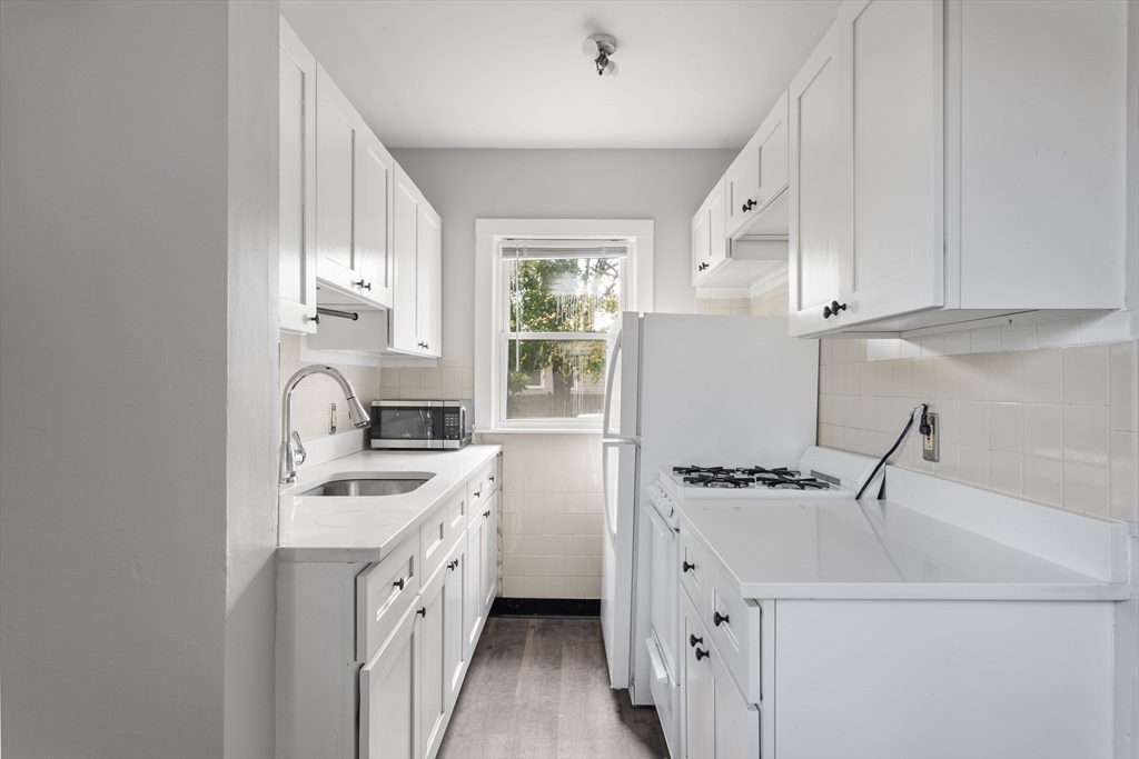 a kitchen with white cabinets and white appliances