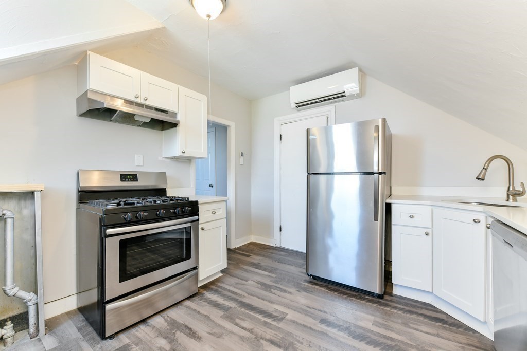 a kitchen with a stove top oven and refrigerator