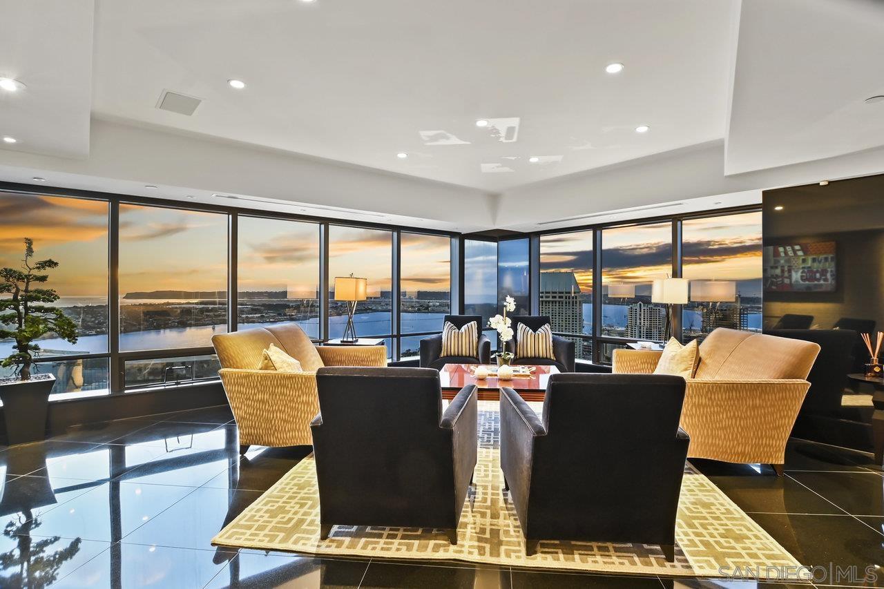 a living room with furniture a rug and a floor to ceiling window