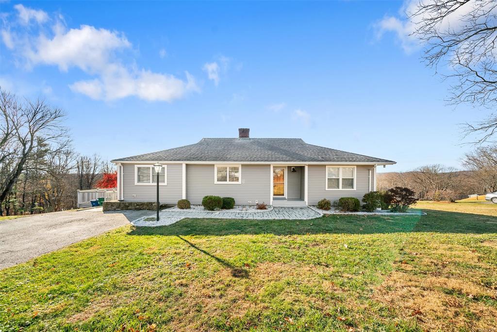 Ranch style home featuring deep front lawn