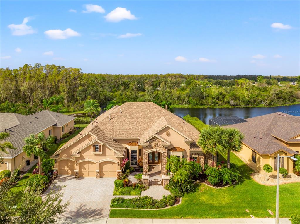 an aerial view of a house with a yard and lake view