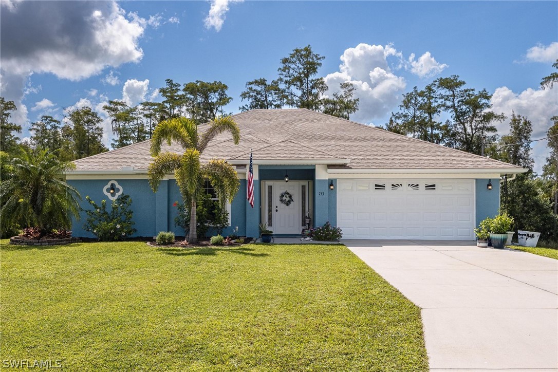 a front view of house with yard and trees in the background