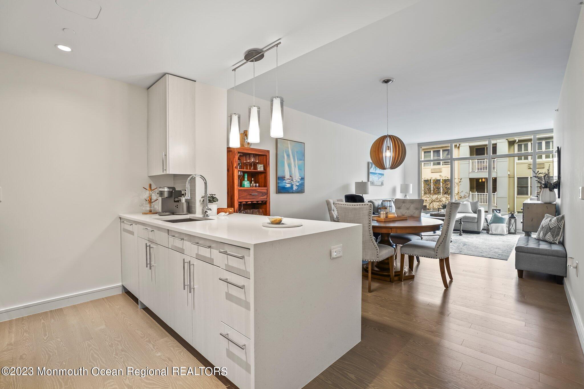 a kitchen with a sink a stove top oven a clock and a window