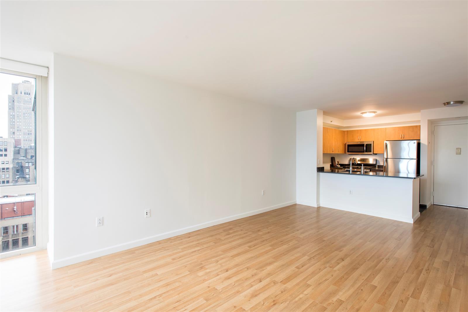 a view of a room with wooden floor and a window