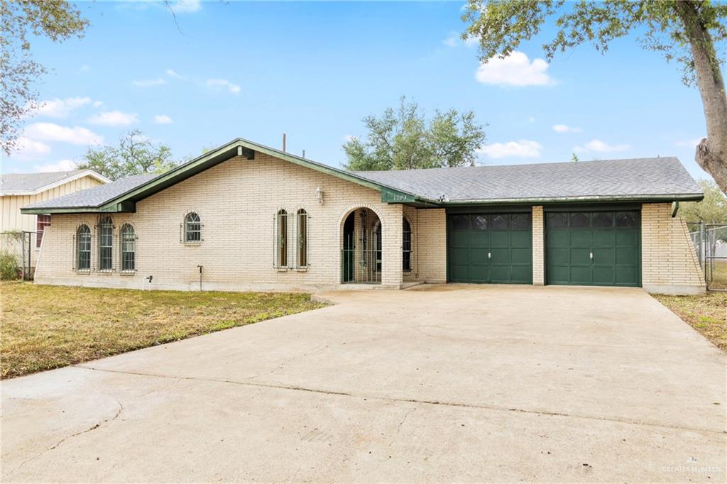 Ranch-style home featuring a front yard and a garage