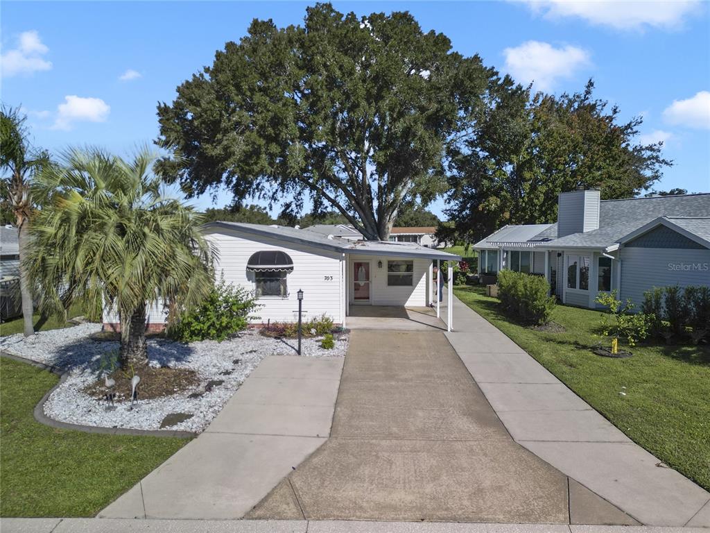 a front view of a house with a yard and potted plants