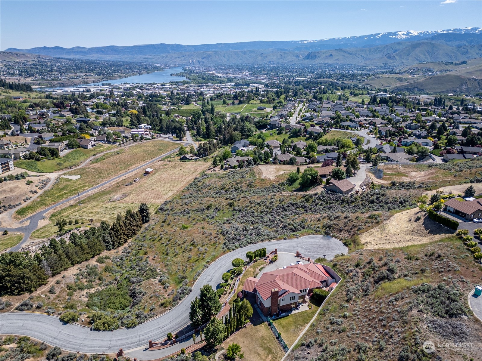 an aerial view of a house with a mountain