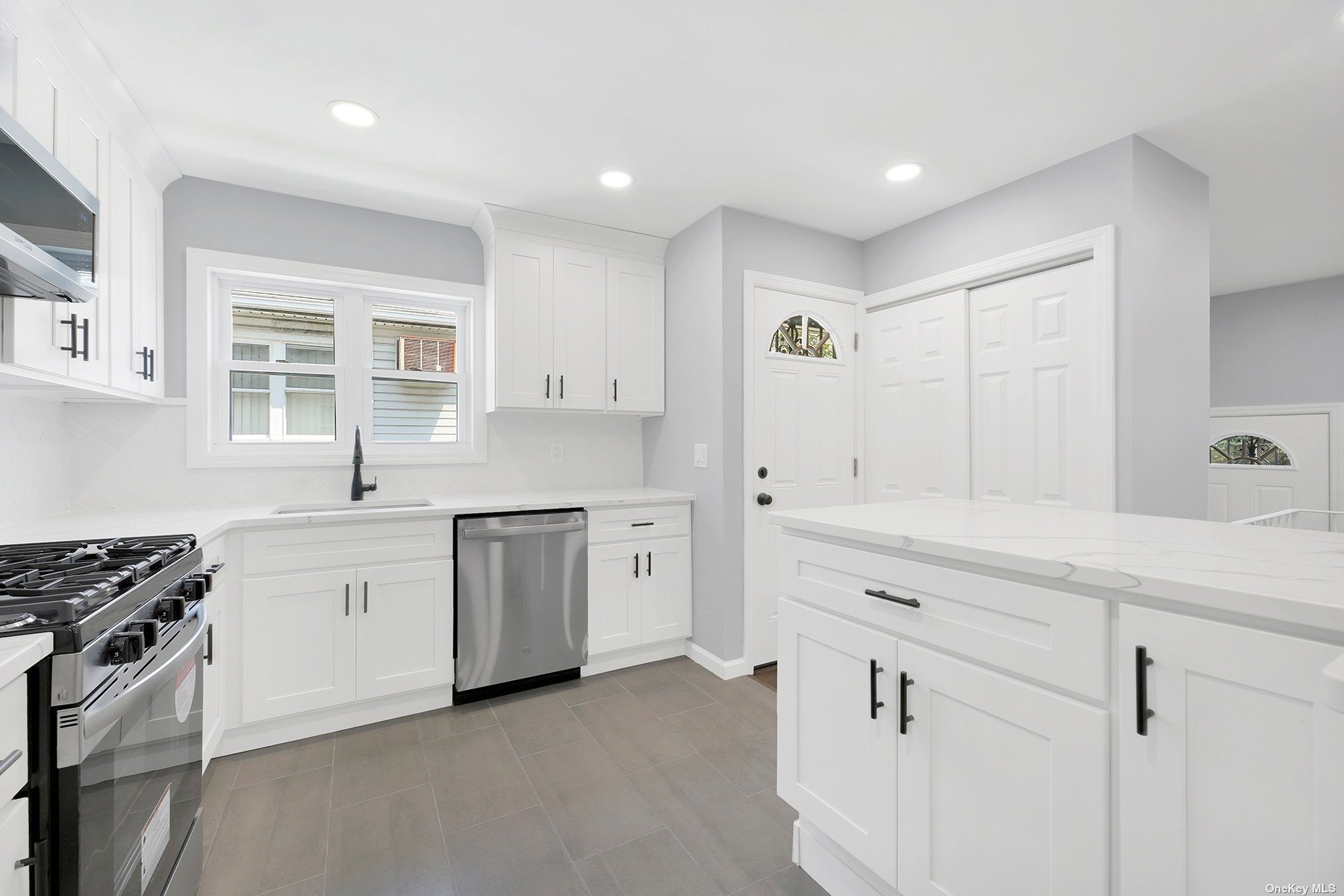 a kitchen with white cabinets and white appliances