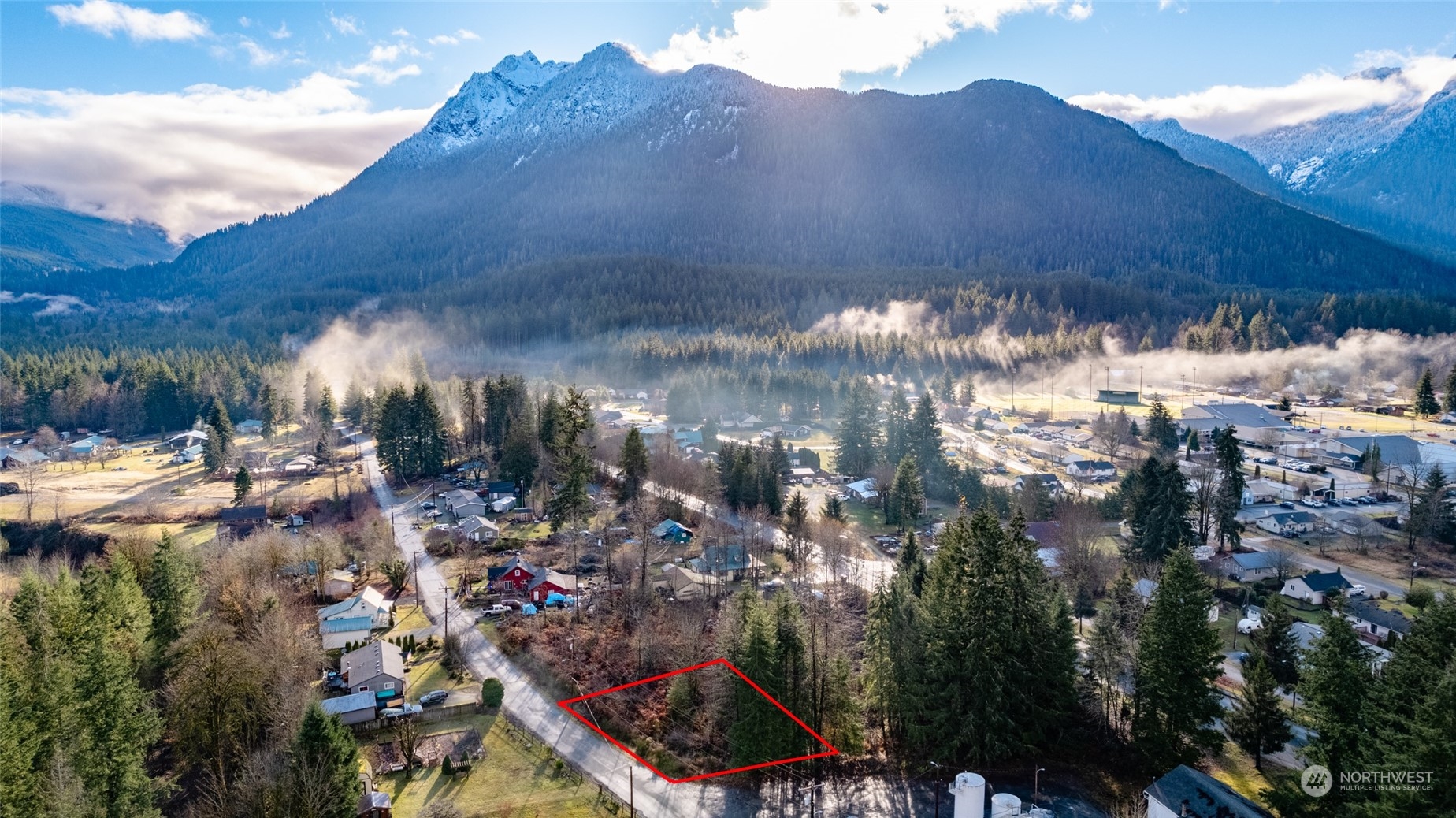 a view of a house with a yard and mountain view in back