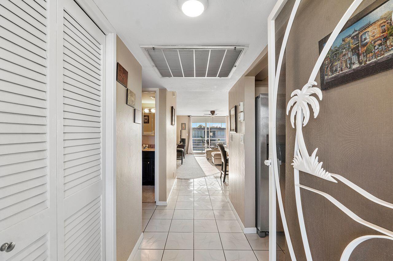 a hallway with a chandelier and a dining table