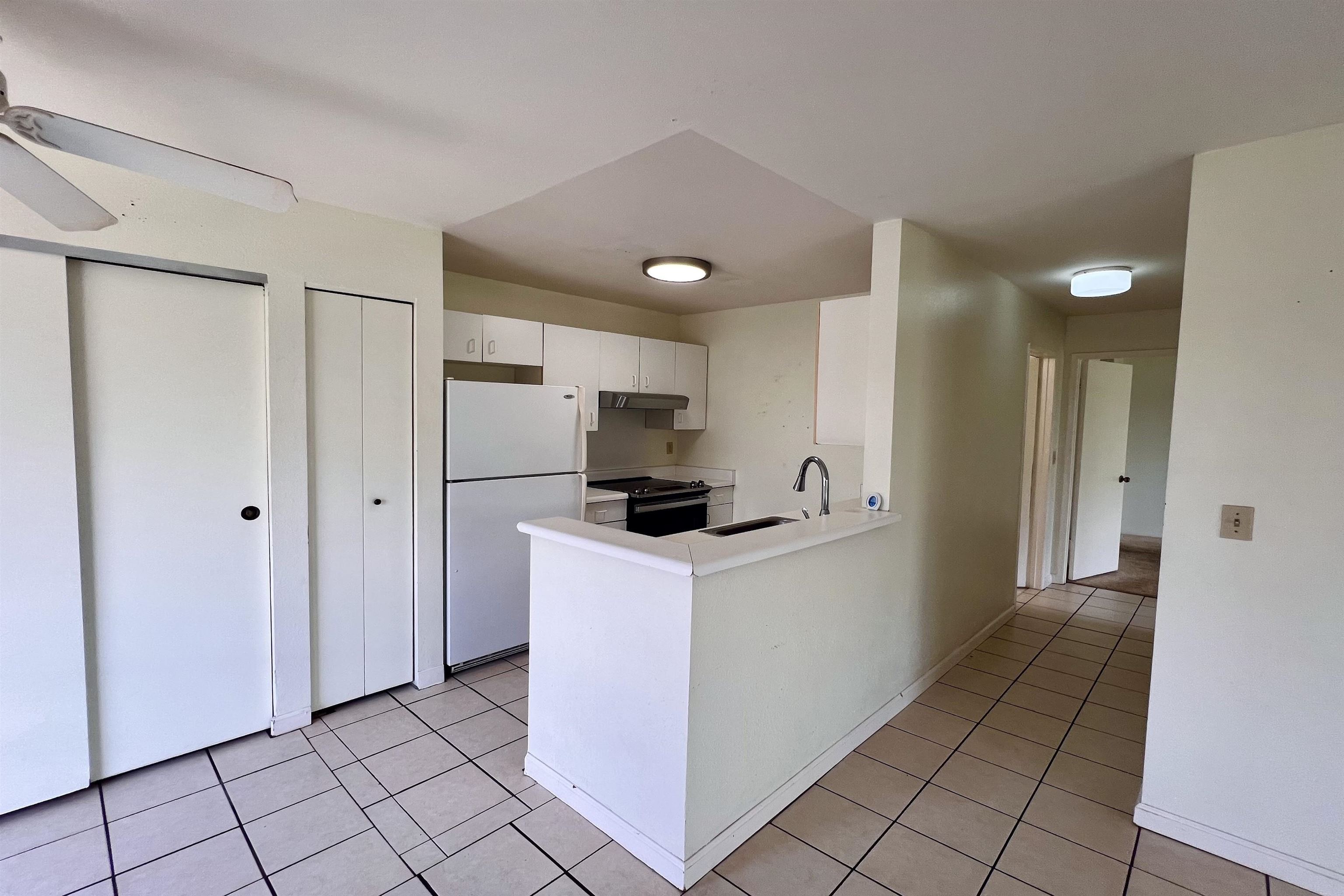 a kitchen with a refrigerator and a stove top oven