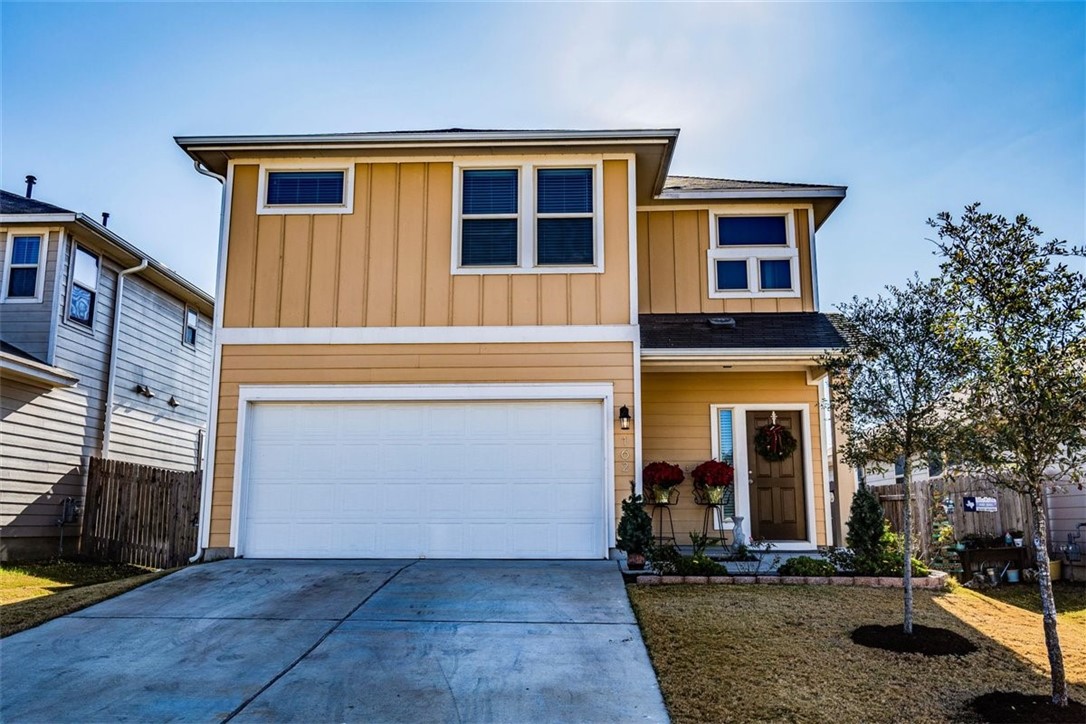 a front view of a house with yard and parking space