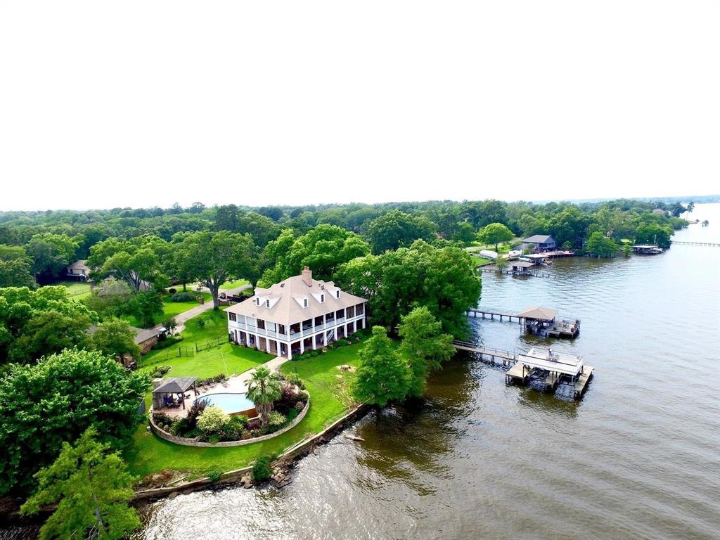 a backyard of a house with lots of green space and lake view