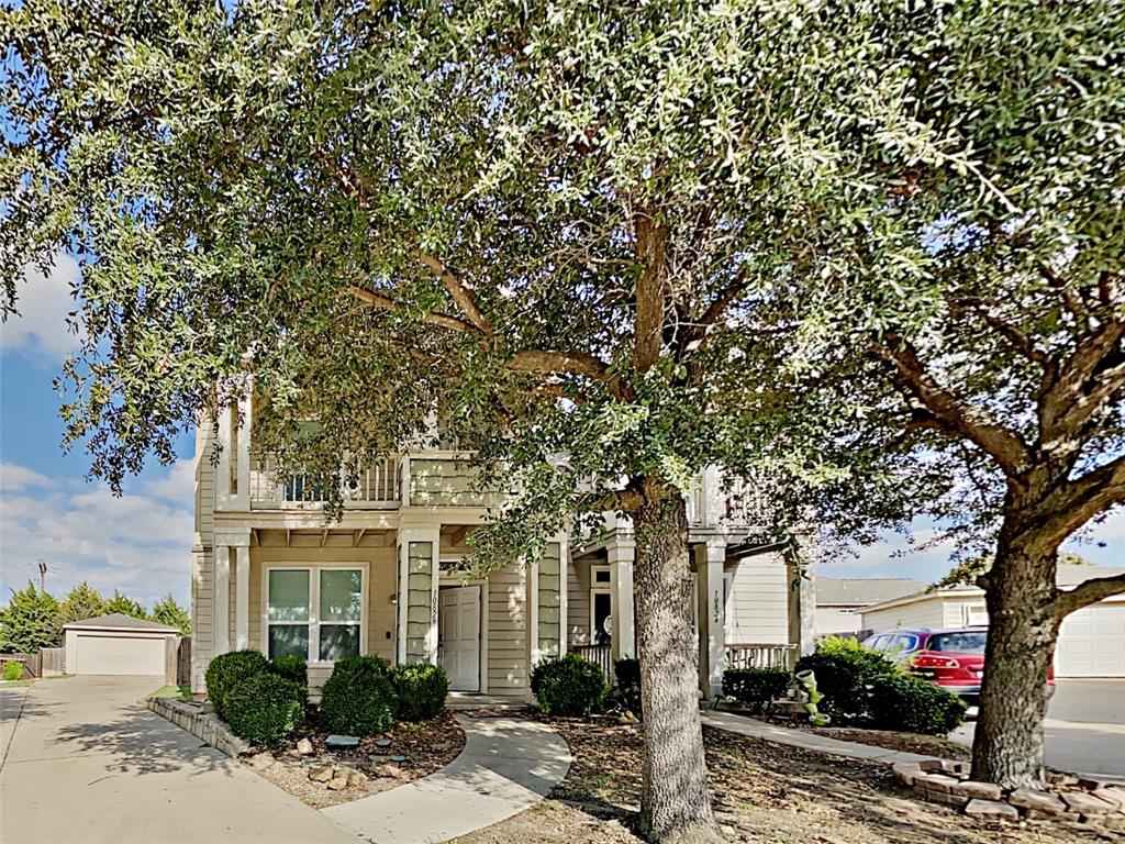 a front view of a house with a tree