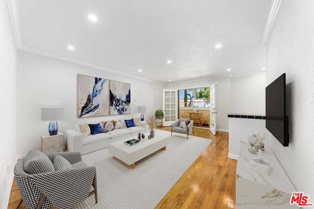 a living room with furniture a flat screen tv and a large window