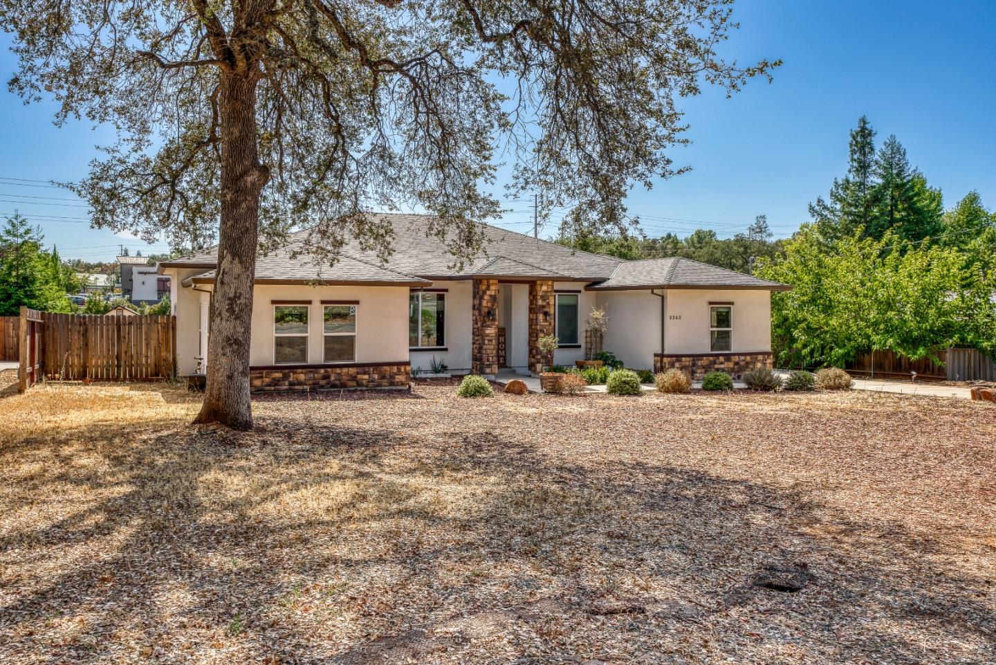 a view of a house with backyard and a tree