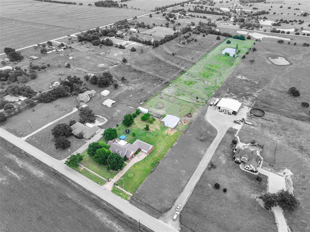 an aerial view of a house with a yard and green space