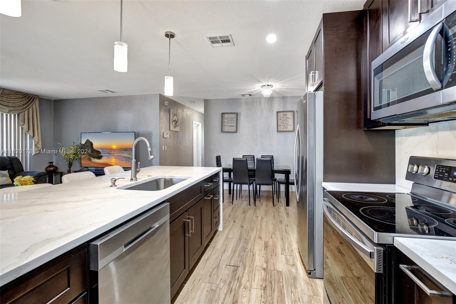 a kitchen with stainless steel appliances granite countertop sink stove top oven and cabinets