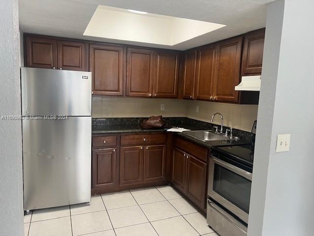 a kitchen with a refrigerator sink and cabinets