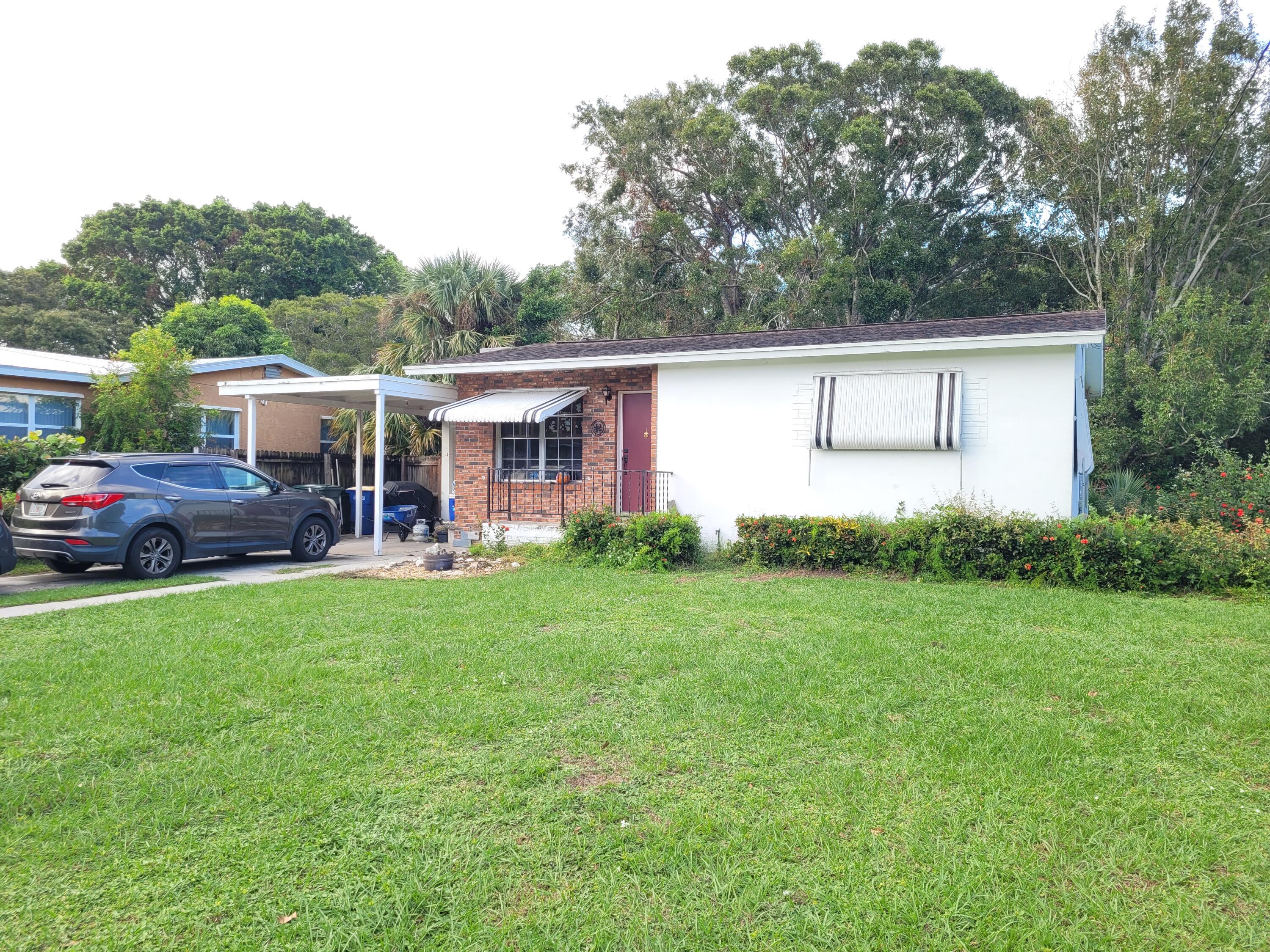 a view of a house with backyard and a garden