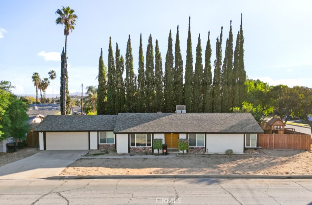 a view of a house with a yard and potted plants