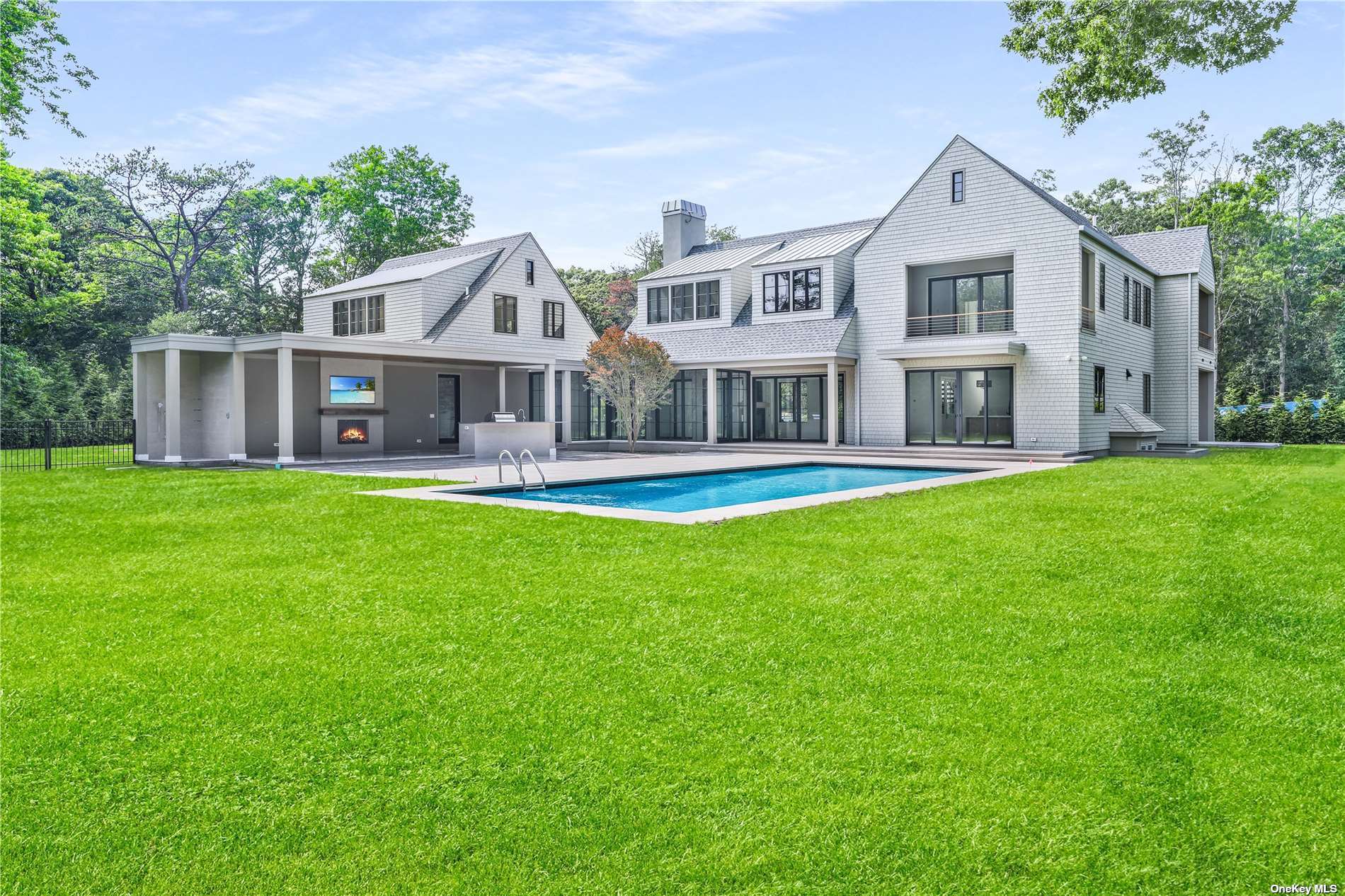 a front view of a house with a yard and large trees