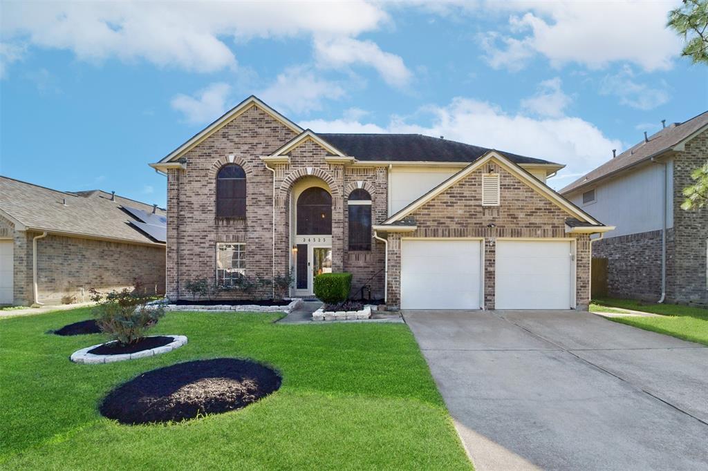 a front view of a house with a yard and garage