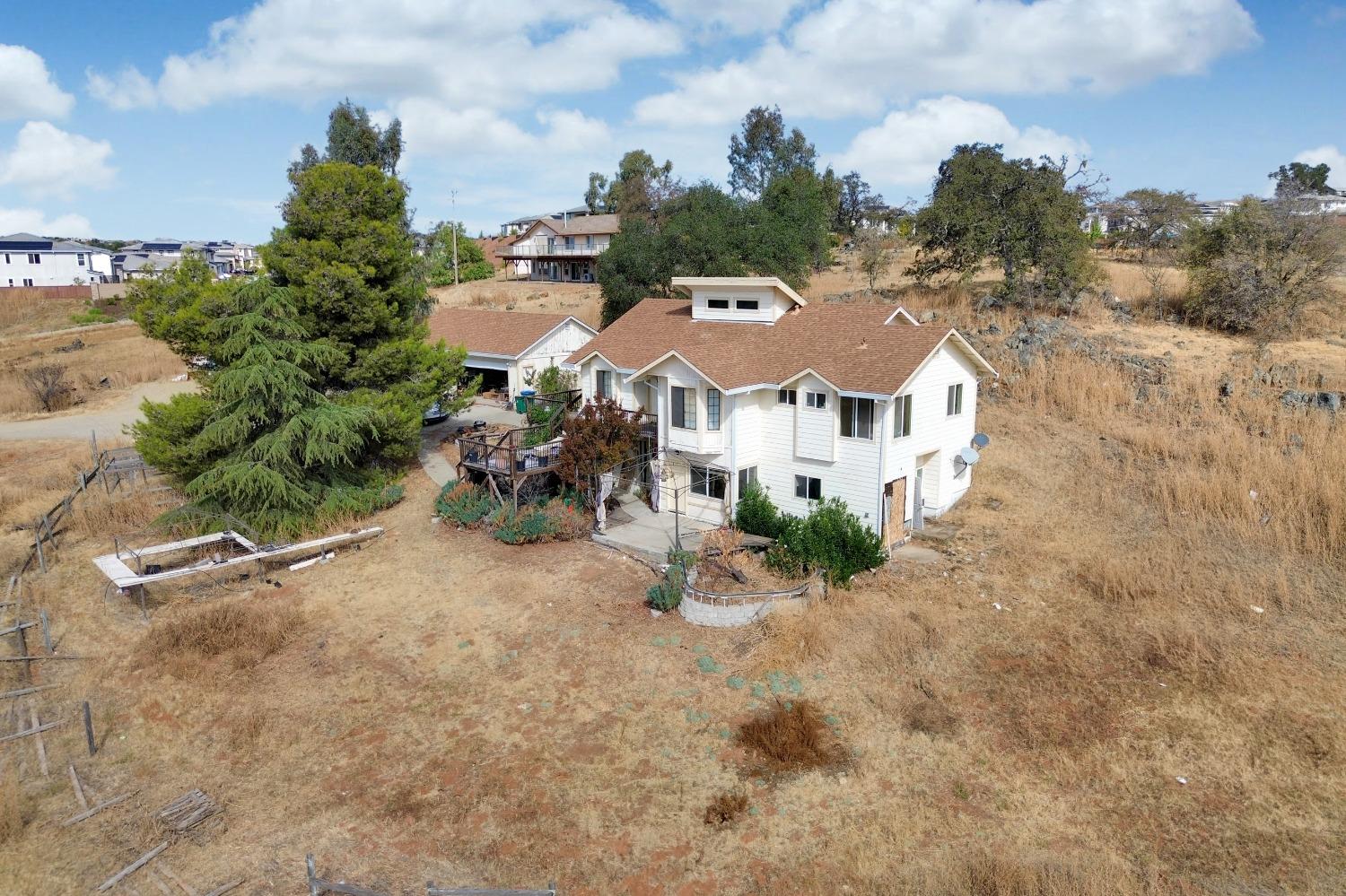 an aerial view of residential houses with outdoor space and trees