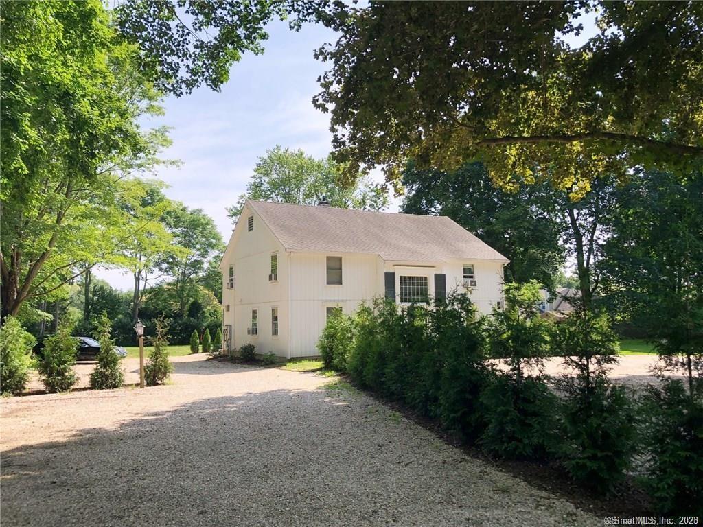 a view of a house with a tree in front of it