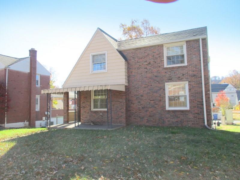 a view of a brick house next to a yard