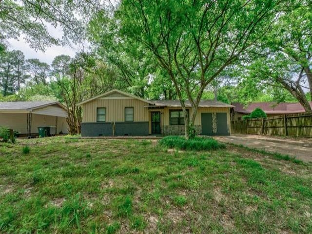 View of front of home featuring a front yard and a garage