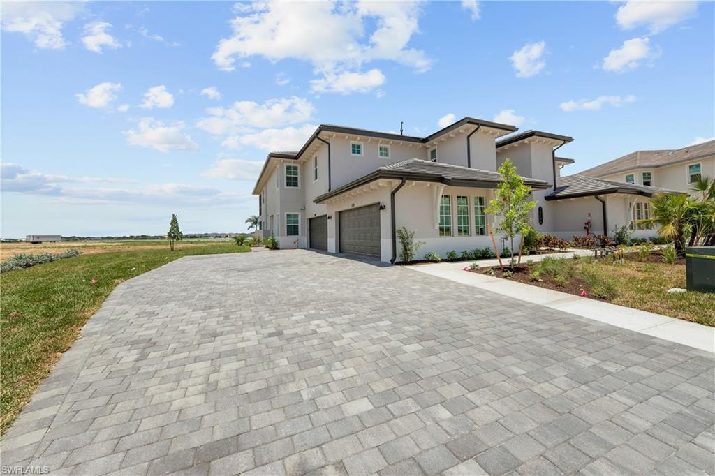 a front view of a house with a yard and lake view