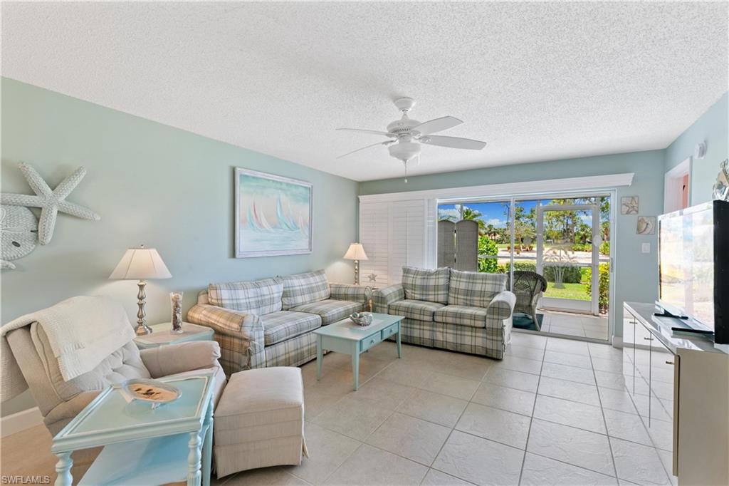 a living room with furniture a flat screen tv and a large window