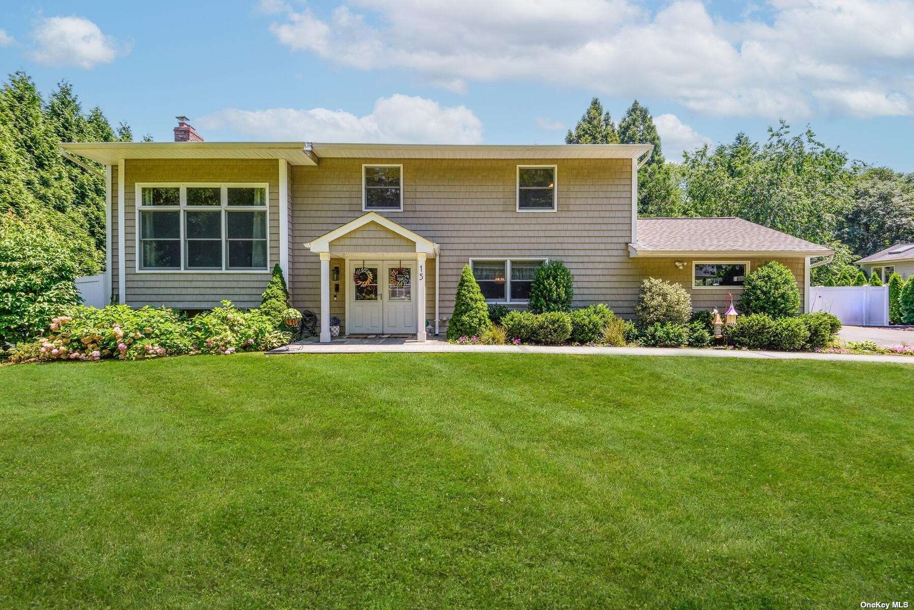 a front view of a house with a yard and potted plants