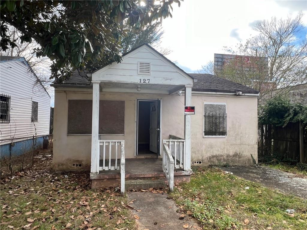 a front view of a house with a tree