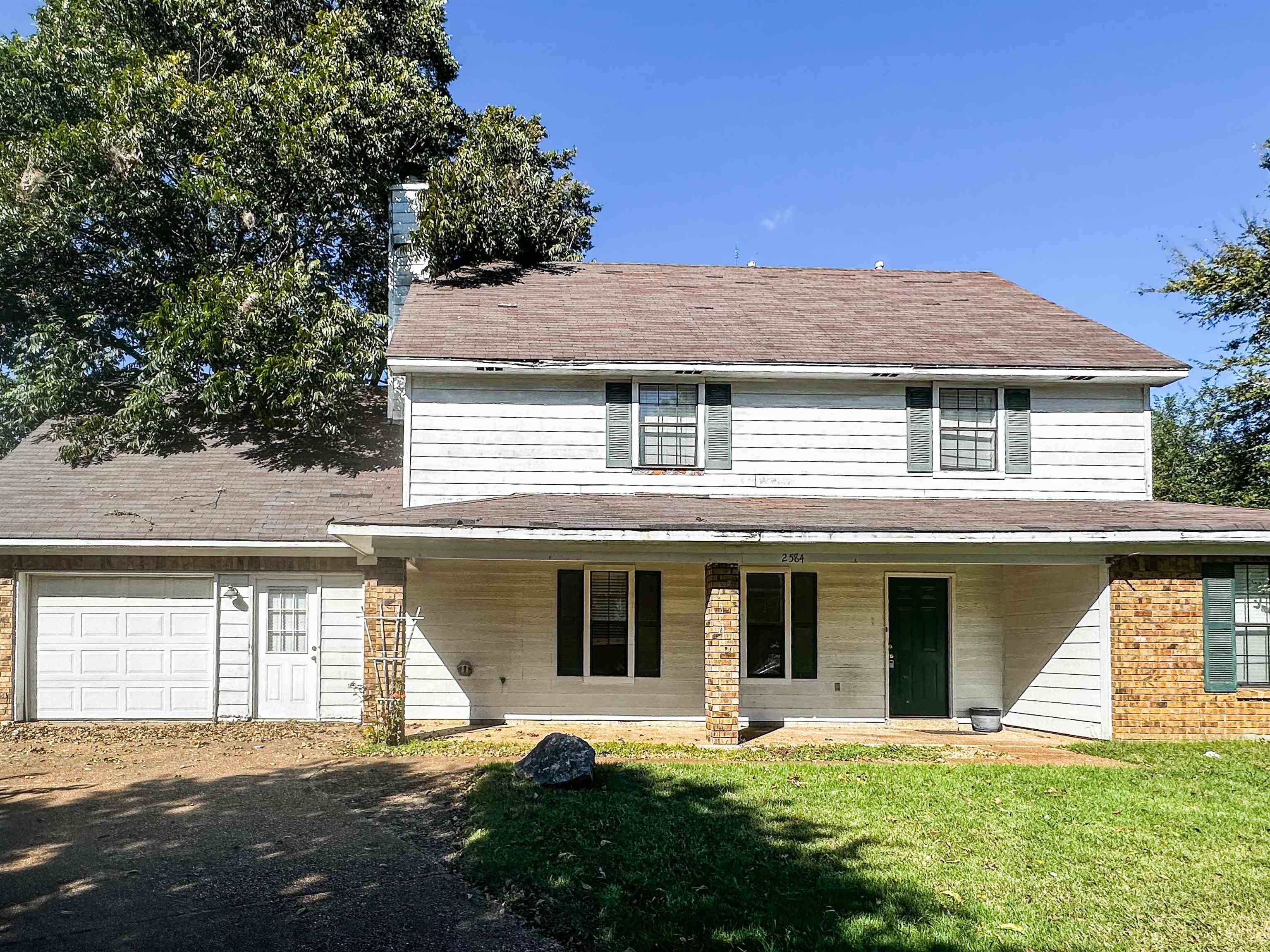 View of front facade featuring a front lawn and a garage