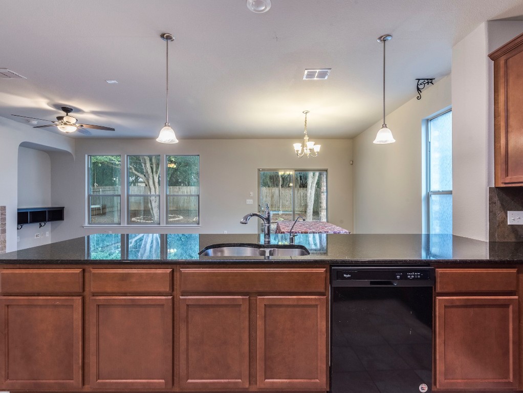 a kitchen with kitchen island granite countertop a sink and a stove