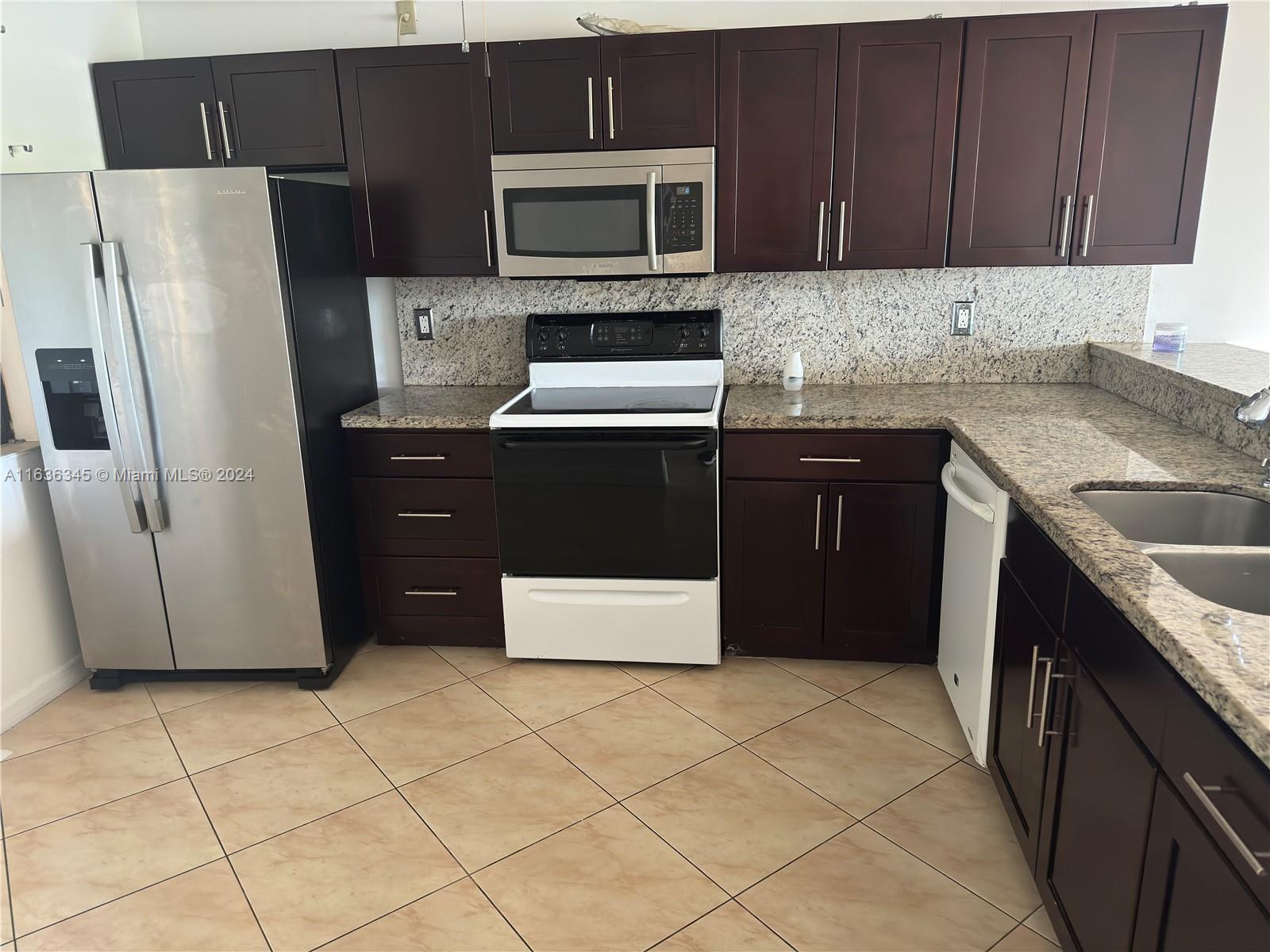 a kitchen with stainless steel appliances granite countertop a refrigerator stove a sink and dishwasher