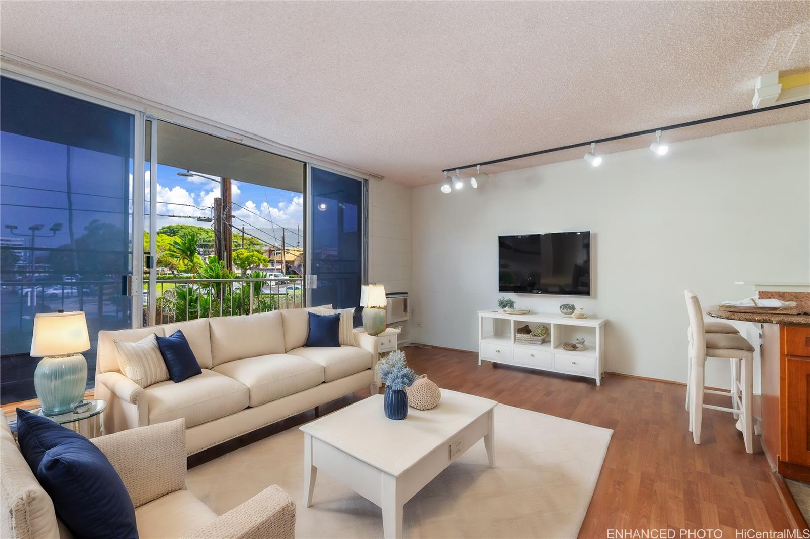 a living room with furniture a flat screen tv and a large window